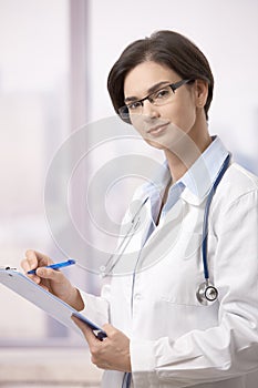 Female physician doing paperwork in hospital