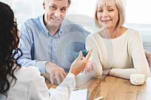 Female physician giving asthma inhaler to senior patients photo