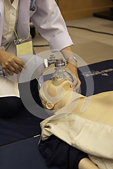 A female physician holding a face mask connected with ambubag on