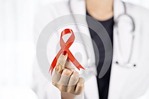 Female physician holding a red ribbon