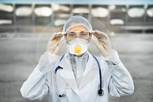 Female physician walking in uniform on front line,fighting viral outbreak.Private protective equipment PPE.Quarantined area