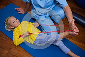 Female physiotherapist assisting a girl patient while exercising