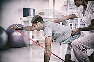 Female physiotherapist assisting a male patient while exercising