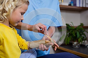 Female physiotherapist giving hand massage to girl patient