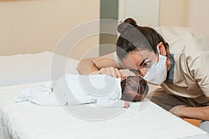 Female physiotherapist performing a pro-decubitus muscle stimulation on a newborn baby. photo