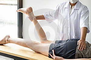 Female Physiotherapist working examining treating injured leg of male patient, Doing exercises the Rehabilitation therapy pain his