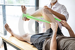 Female Physiotherapist working examining treating injured leg of male patient, Doing exercises the Rehabilitation therapy pain his