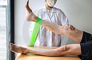 Female Physiotherapist working examining treating injured leg of male patient, Doing exercises the Rehabilitation therapy pain his