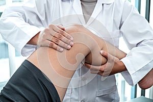 Female Physiotherapist working examining treating injured leg of patient, Doing exercises the Rehabilitation therapy pain his in