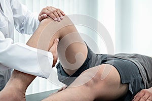 Female Physiotherapist working examining treating injured leg of patient, Doing exercises the Rehabilitation therapy pain his in