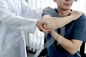 Female physiotherapists provide assistance to male patients with elbow injuries examine patients in rehabilitation centers.