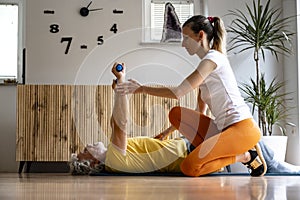 Female physiotherapy practitioner working with a senior man on his rehabilitation