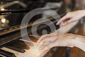 Female pianist hands on grand piano keyboard.Playing music or song at home.