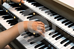 A female pianist plays a three- manual electronic organ