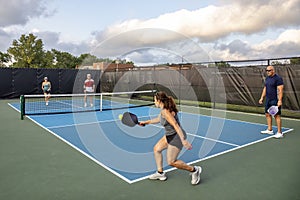 Female Pickleball Player Returns Ball