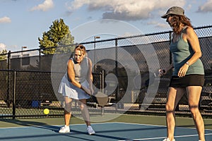 Female Pickleball Player Returns Ball