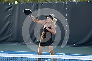 Female Pickleball Player Returns High Ball