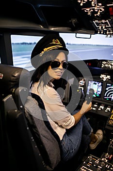 Female Pilot in the Airplane Cockpit. Pilot wearing sun glasses and hat