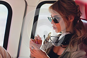 Female pilot in cockpit of helicopter before take off. Young woman helicopter pilot.