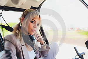 Female pilot in cockpit of helicopter before take off. Young woman helicopter pilot.