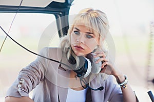 Female pilot in cockpit of helicopter before take off. Young woman helicopter pilot.