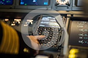 Female pilot inserting flight information into plane system. Airplane control panel.