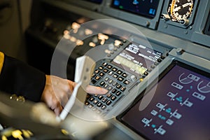 Female pilot inserting flight information into plane system. Airplane control panel.