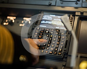Female pilot inserting flight information into plane system. Airplane control panel.