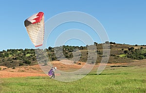 Female pilot landing with a paraglider