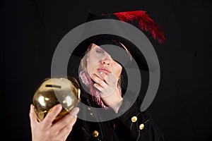 Female in a pirate costume holding a golden piggy bank with a thoughtful look