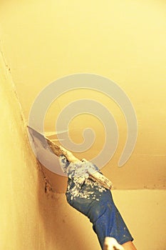 Female plasterer painter repairing a ceiling indoor