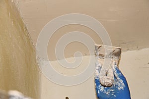 Female plasterer painter repairing a ceiling indoor