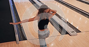 Female player throwing ball on bowling alley. Unrecognizable woman bowler playing bowling throwing ball to skittles