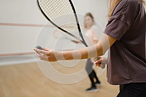 Female players with squash rackets, focus on ball