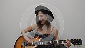 Female playing on electric guitar. Woman playing country style song on guitar. Stylish young girl playing on guitar