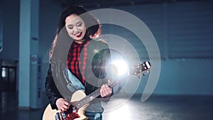 Female playing the guitar in hangar