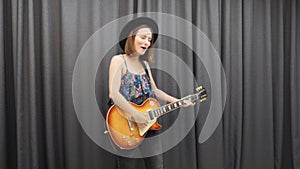 Female playing on guitar. Woman enjoying her guitar playing and singing. Girl singing lyric romantic song and playing on guitar