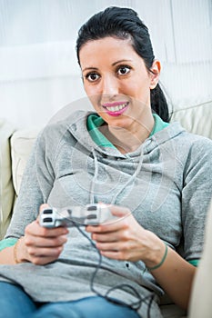 Female playing video-games concentrating on sofa