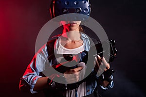 Female playing VR shooter game with virtual reality gun and glasses
