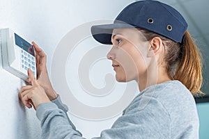 female plumber adjusting thermostat