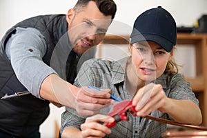 female plumber apprentice working with cooper pipes