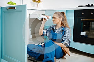 Female plumber fixing problem with drain pipe