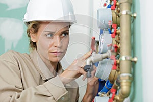 female plumber fixing water meter with adjustable wrench