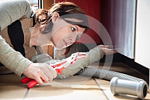 female plumber installs or repairs a dishwasher