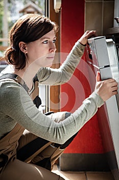 female plumber installs or repairs a dishwasher