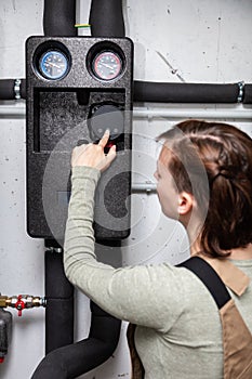 female plumber with a pellet heating system in the basement