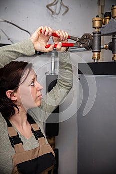 female plumber with a pellet heating system in the basement