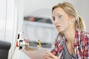 female plumber working on central heating boiler