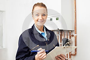 Female Plumber Working On Central Heating Boiler