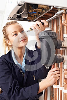 Female Plumber Working On Central Heating Boiler